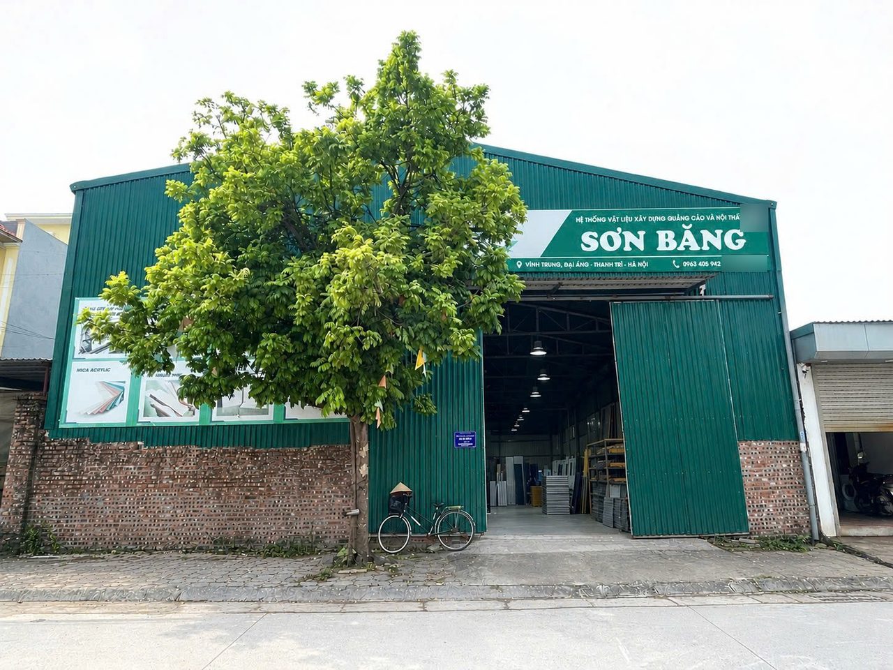 Mặt tiền kho Sơn Băng Hà Nội: nhà kho tôn xanh, biển hiệu Sơn Băng, cửa kho mở ra đường