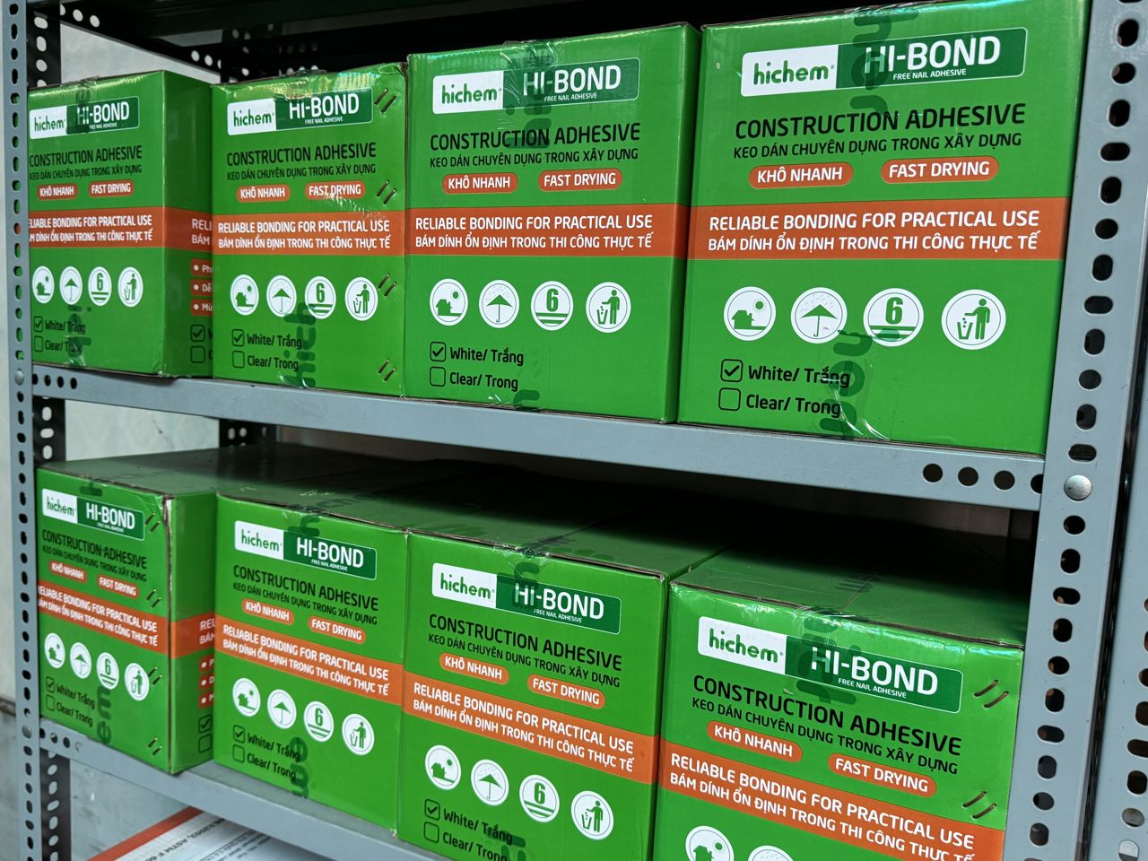 Thùng keo Hi-Bond Hichem màu trắng và màu trong xếp trên kệ kho Sơn Băng